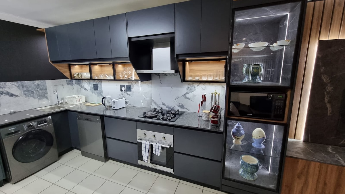 Fully equipped kitchen with washer/dryer combo, dishwasher, gas stove and oven, microwave and fridge.