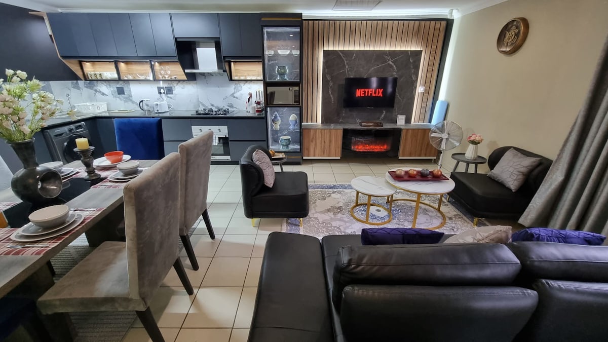 Open plan living room area with TV with Netflix subscription and LED electric fireplace. The is a sofa couch that coverts to a single bed.