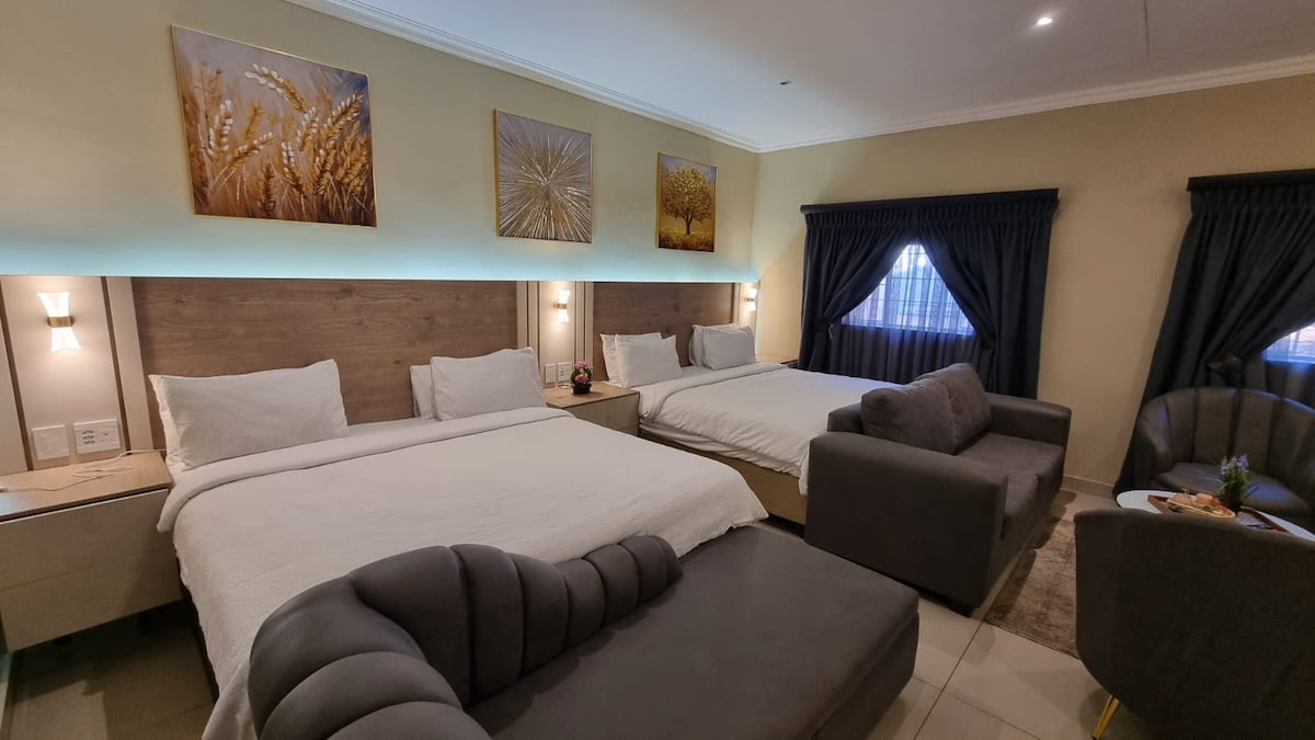 Two LED-lit king sized beds side by side that sleeps four comfortably. Electric blankets installed on the beds.