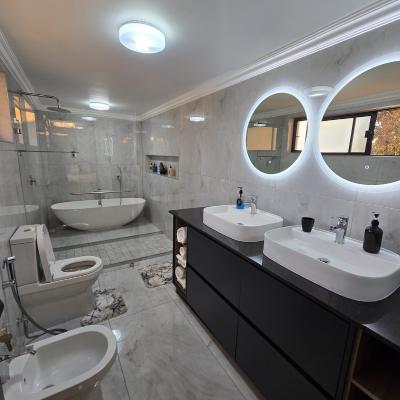 Large ensuite bathroom with double vanity, bidet shower and bathtub.