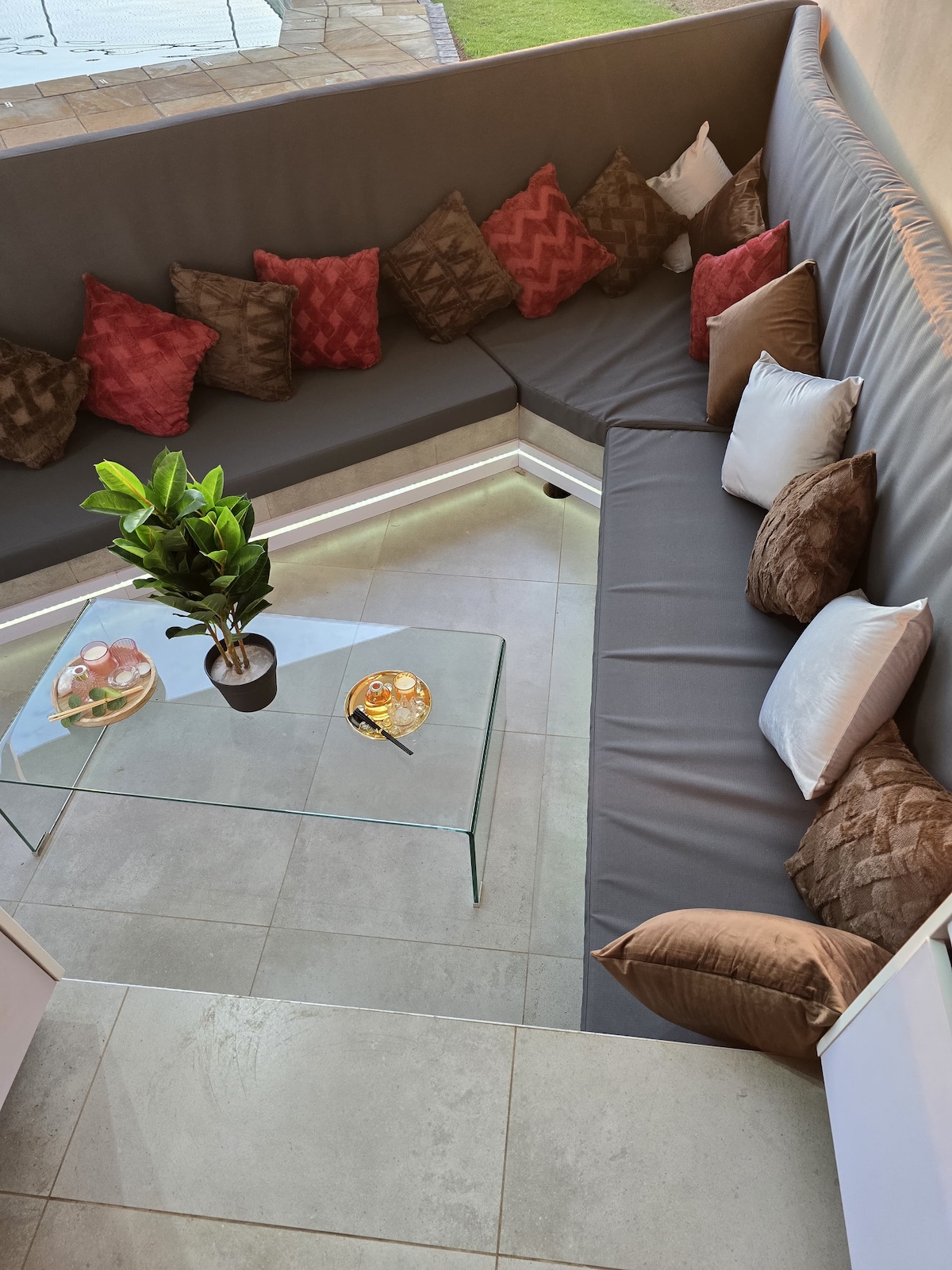 Sunken outdoor seating area by pool and outdoor braai area