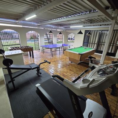 Entertainment area with pool table, table tennis table, foosball, and gym equipment with weights, cycling machine and treadmill