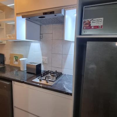 Kitchen with gas stove, dishwasher, microwave oven, fridge and basic cooking utensils.