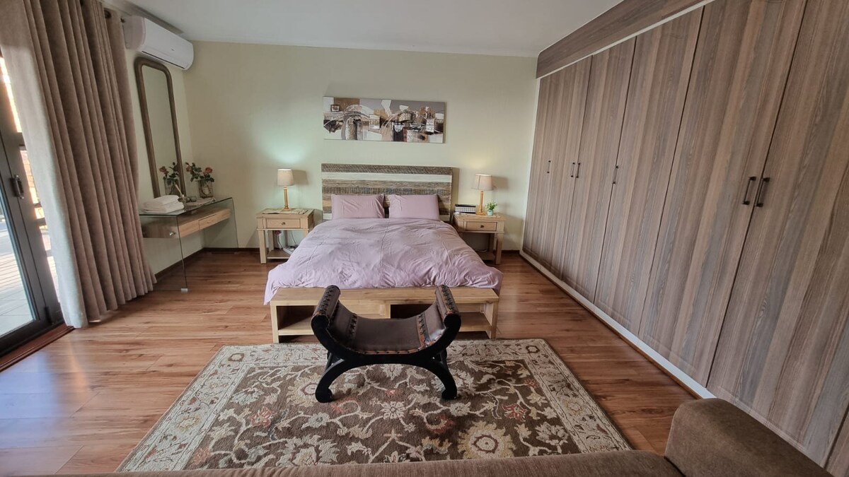 Queen sized bed with electric blankets and seating couch and with a view to northern JHB.
