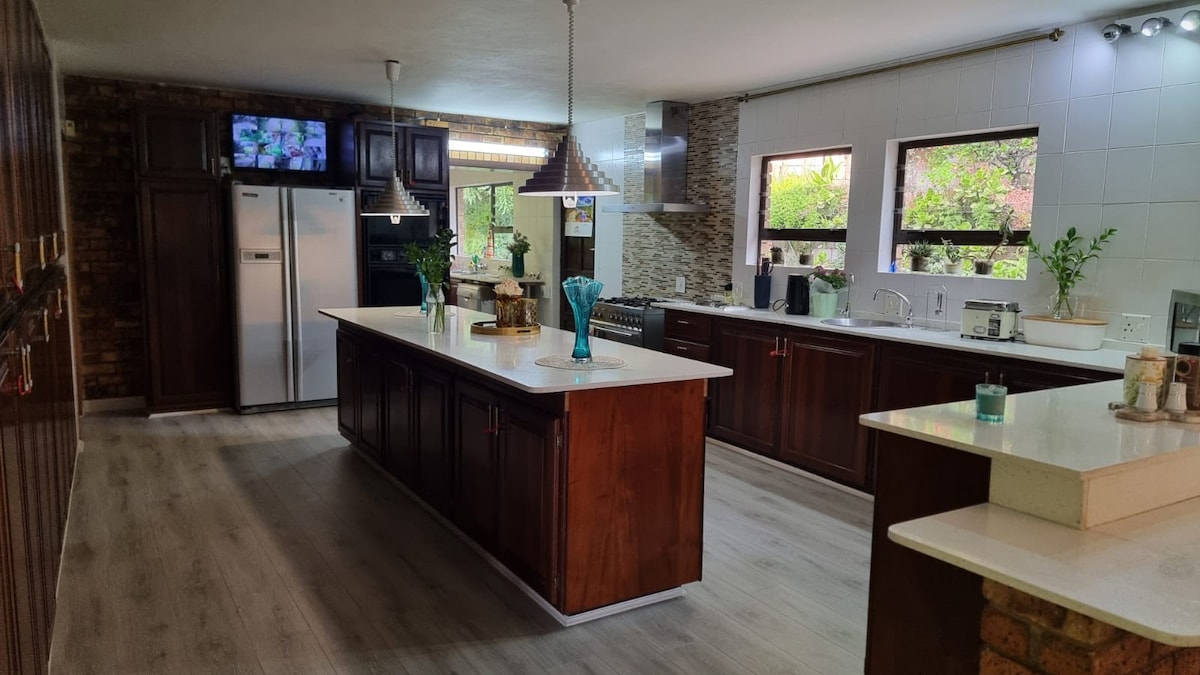 Open plan kitchen with all cooking utensils, gas stove, kettle, toaster, microwave and fridge