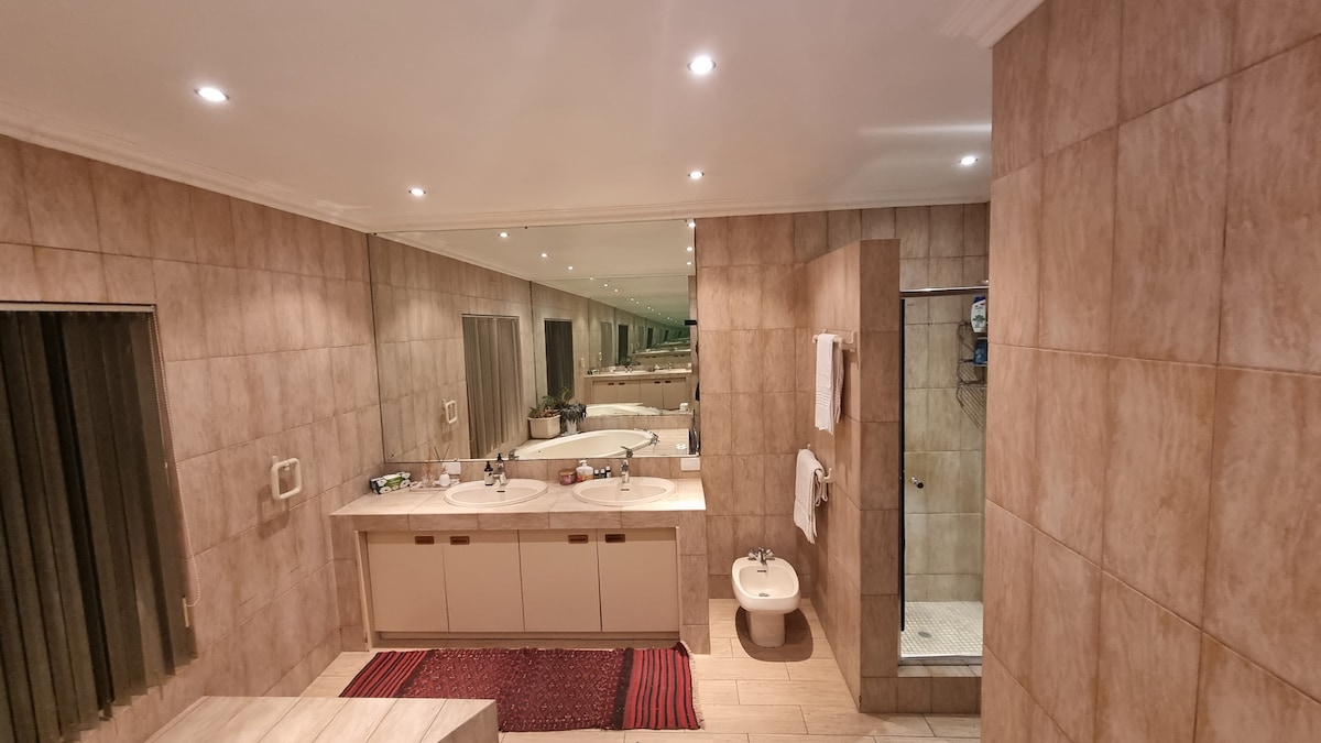 Ensuite master bathroom with large bath tub, two sinks, bidet and shower.