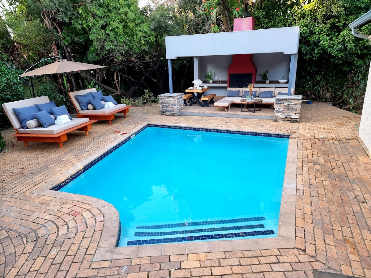 Solar heated pool that is available year around over looking a covered patio area with a BBQ/Braai oven with outdoor lounge furniture.
