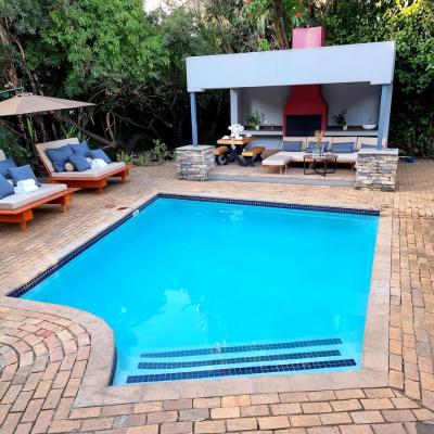 Solar heated pool that is available year around over looking a covered patio area with a BBQ/Braai oven with outdoor lounge furniture.
