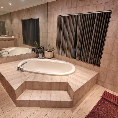 Ensuite master bathroom with large bath tub, two sinks, bidet and shower.
