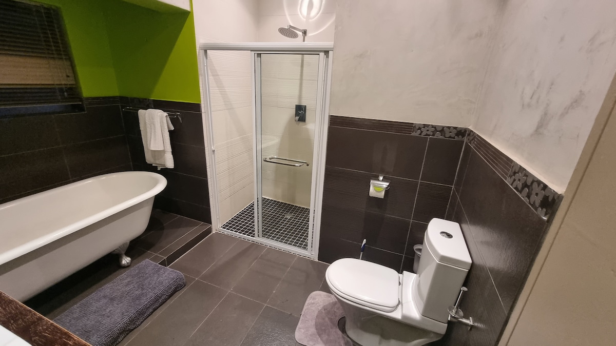 Bathroom with both a shower and a bath tub. Hot water is supplied from a large solar geyser.