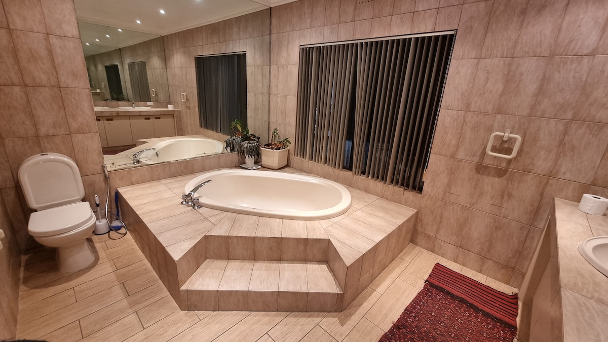 Ensuite master bathroom with large bath tub, two sinks, bidet and shower.
