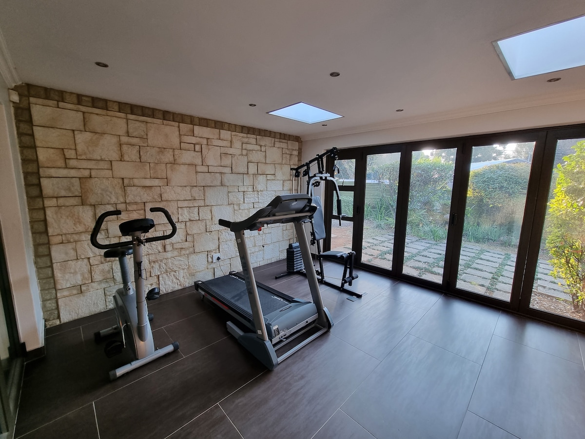 Gym with stationary bike, treadmill, and trojan weight power gym