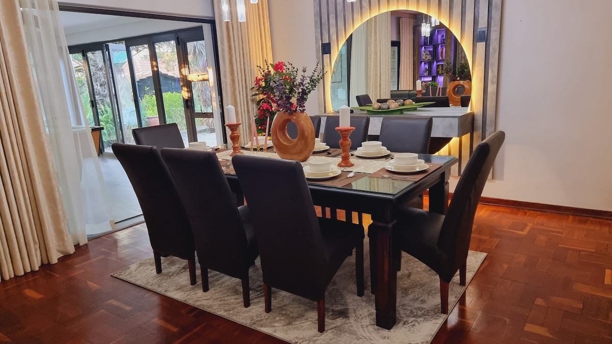 Eight seater dining room with LED lit table server with circular mirror.