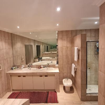 Ensuite master bathroom with large bath tub, two sinks, bidet and shower.
