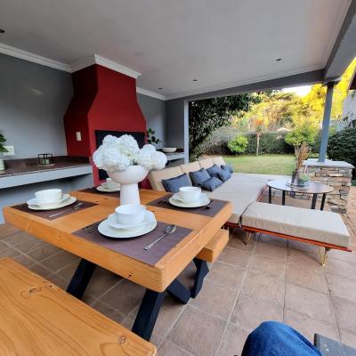 Covered patio area with BBQ/Braai oven, dining table and L-shaped couch