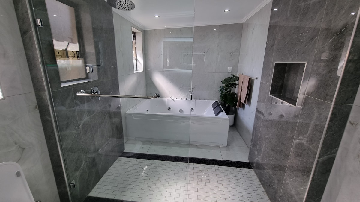 Massive bathroom with open shower and jacuzzi.