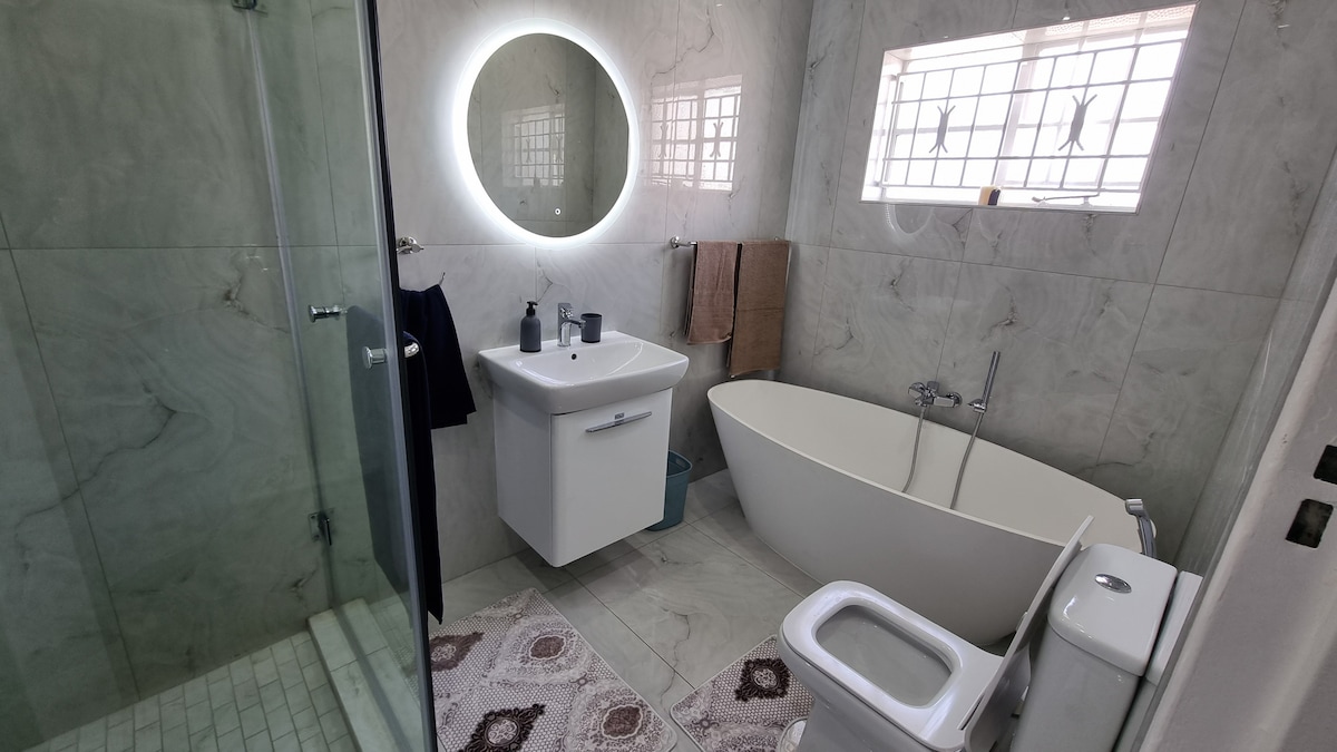 Full bathroom with shower cubicle and freestanding bathtub.