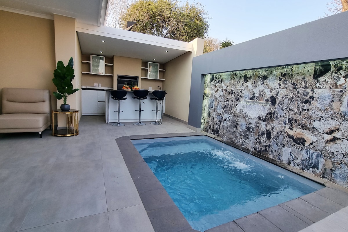 Outdoor entertainment area with fountain splash pool, outdoor kitchen and braai/bbq place.