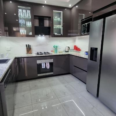Fully stocked modern kitchen with gas stove and oven, dishwasher, microwave and side by side cabinet fridge.